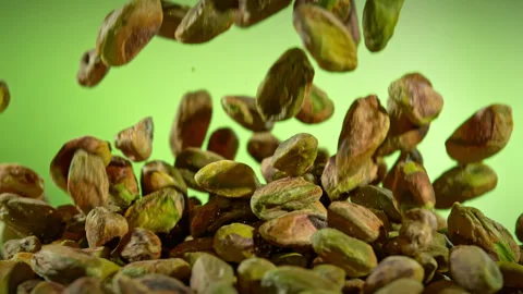 Super Slow Motion Shot of Falling Peeled Pistachio Nuts on Green Gradient Stock Footage 312091749