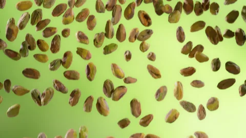 Super Slow Motion Shot of Falling Peeled Pistachio Nuts on Green Gradient Stock Footage 312810988
