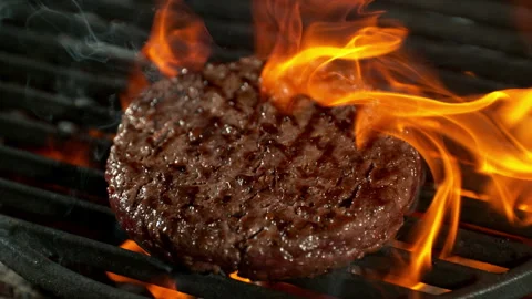 Super Slow Motion Shot of Flipping Hamburger Meat on Hot Grill with Flames and Stock Footage 306799555