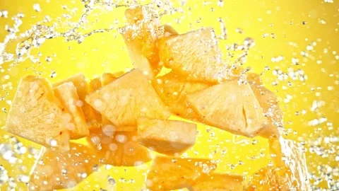 Super Slow Motion Shot of Flying Fresh Pineapple Slices and Water Side Splash at Video stock 157611548