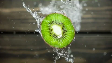Super Slow Motion Shot of Flying Kiwi Slices and Splashing Water on Grey Stock Footage 206062972