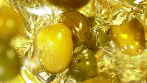 Super Slow Motion Shot of Fresh Green Olives Splashing into Olive Oil Video stock 144131918