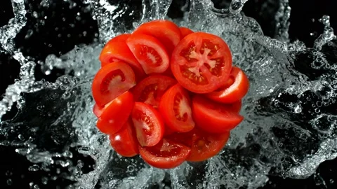 Super Slow Motion Shot of Fresh Tomato Cuts and Water Splash Isolated on Black Stock Footage 229145394