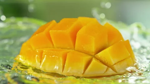 Super Slow Motion Shot of Fresh Mango Falling into Water and Making Splash at Stock Footage 339436117
