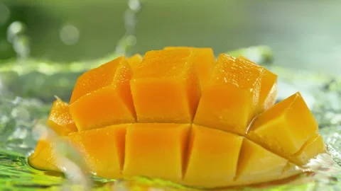 Super Slow Motion Shot of Fresh Mango Falling into Water and Making Splash at Stock Footage 340459938