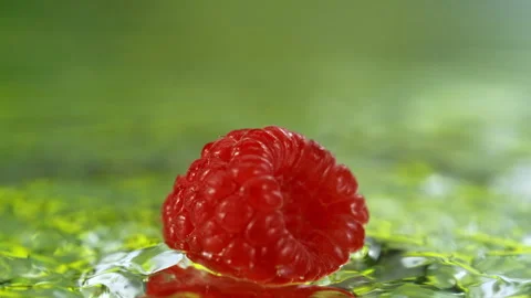 Super Slow Motion Shot of Fresh Raspberry Falling into Water and Making Splash Stock Footage 341293712