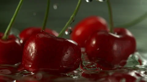 Super Slow Motion Shot of Fresh Cherries Falling into Water and Making Splash at Stock Footage 341832787