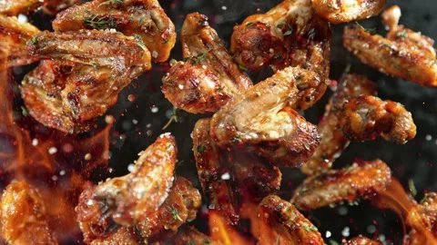 Super Slow Motion Shot of Grilled Spicy Chicken Wings Flying Towards Camera at Stock Footage 214371630