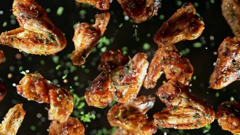 Super Slow Motion Shot of Grilled Spicy Chicken Wings Flying Towards Camera at Stock Footage 216532534
