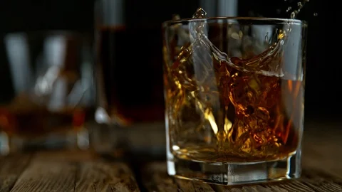 Super Slow Motion Shot of Ice Drop into Glass with Whiskey at 1000fps with Stock Footage 122873379