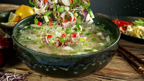 Super Slow Motion Shot of Ingredients Falling into Chicken Pho Soup at 1000 fps. Vidéo 142559632