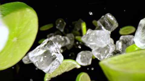 Super Slow Motion Shot of Lime Slices and Ice Cubes Falling on Black Background Stock Footage 149481205