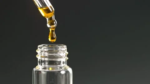 Super Slow Motion Shot of Oily Essence Drop into Phial on Dark Background at Stockbeeldmateriaal 159511652