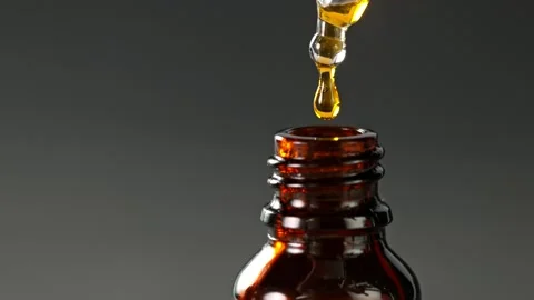 Super Slow Motion Shot of Oily Essence Drop into Phial on Dark Background at Stockbeeldmateriaal 160096832