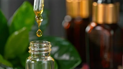 Super Slow Motion Shot of Oily Essence Drop into Phial on Dark Background at Stockbeeldmateriaal 161125525