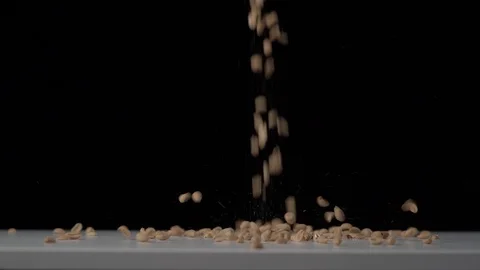 Super slow motion shot of peanuts falling on white table Stock Footage 126145269