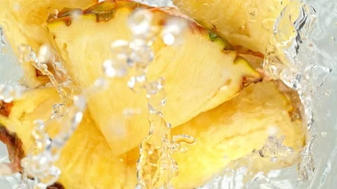 Super Slow Motion Shot of Pineapple Slices Falling Into Water Whirl at 1000 fps. Stock Footage 157185274