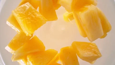 Super Slow Motion Shot of Pineapple Cuts Followed by Camera Falling into Yogurt Stock Footage 274532313