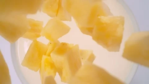 Super Slow Motion Shot of Pineapple Cuts Followed by Camera Falling into Milk at Stock Footage 276313469