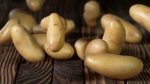Super Slow Motion Shot of Potatoes Rolling on Old Wooden Table at 1000fps. Stock Footage 130050598