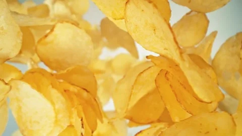 Super Slow Motion Shot of Premium Potato Chips Falling Down on Light Background Stock Footage 257576551