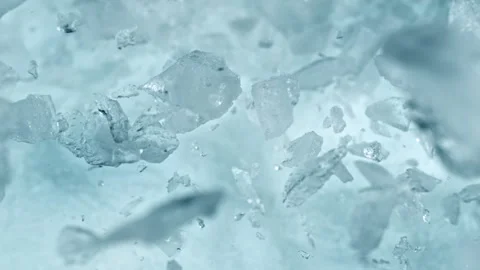 Super Slow Motion Shot of Real Ice Pieces Exploding Towards Camera on Light Stock Footage 328582962
