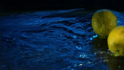 Super Slow Motion Shot of Rolling 2 limes Splashing Water from Rotating Lime Stock Footage 201170803