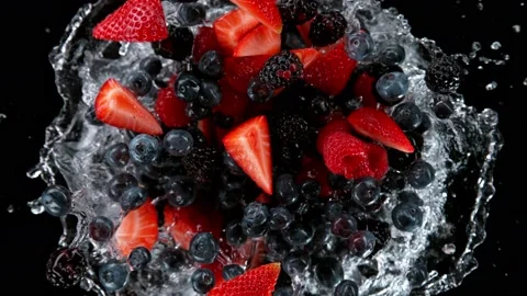 Super slow motion shot of rotating exploded berries fruit with splashing water Video stock 171470990