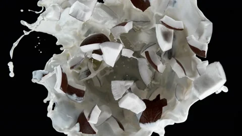 Super slow motion shot of rotating exploded coconut cuts and splashing milk on Video stock 171566711