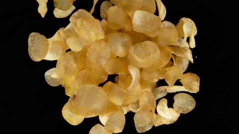 Super slow motion shot of rotating exploded salted potato chips on black at Stock Footage 173551504