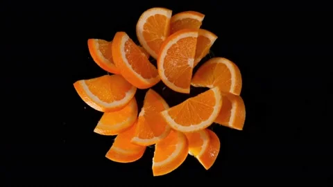 Super slow motion shot of rotating exploded orange slices on black at 1000fps. Video stock 177528456
