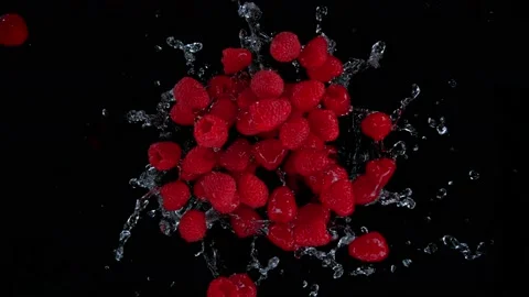 Super slow motion shot of rotating exploded raspberries with splashing water on Stock Footage 184684866
