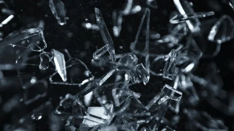 Super Slow Motion Shot of Shattering Glass Shards Flying Towards Camera on Black Video stock 212542282