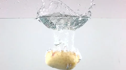 Super slow motion shot of single potato falling in water with light background Stock Footage 60416662
