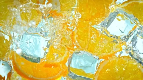 Super Slow Motion Shot of Water Wave Splashing on Orange Slices and Ice Cubes at Stock Footage 246437563