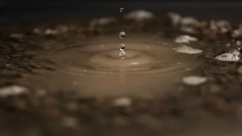 Super Slow Motion Shot of Water Dropping Into a Puddle Stock Footage 270409336