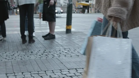 Super slow motion shot of a young woman swinging colorful shopping bags in the Vidéo 116504475