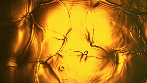 Super slow motion of splashing whiskey, cognac or oil surface. Stock Footage 194181236