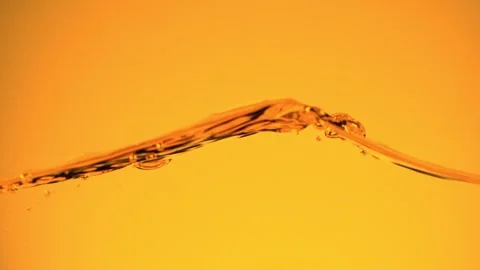 Super slow motion of splashing whiskey, cognac or oil surface. Stock Footage 249164191