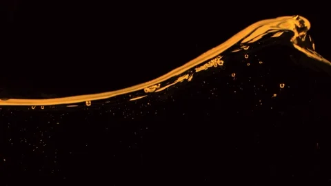 Super slow motion of splashing whiskey, cognac or oil surface. Stock Footage 249164252
