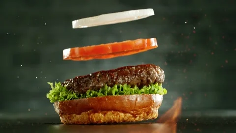 Super slow motion of stacking hamburger pieces with fire. Stock Footage 243025302