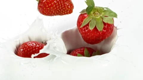 Super slow motion of strawberries falling into milk Stock Footage 134171942