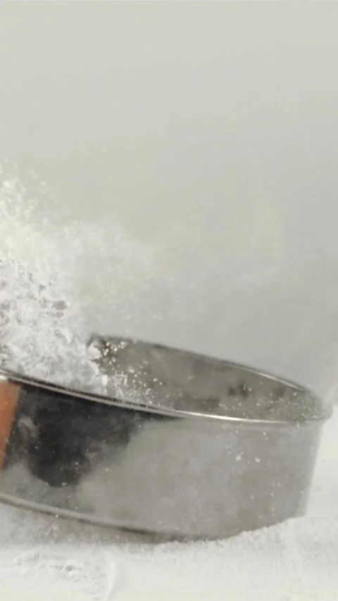 Super slow motion on the table with flour falling sieve. Filmed on a high-speed Stock Footage 335287472