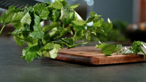 Super slow motion of throwing fresh coriander with kitchen knife. Stock Footage 166960690