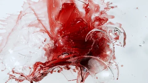 Super Slow Motion Top Shot of Breaking Glass with Red Wine on White Cloth at Stock Footage 125318511