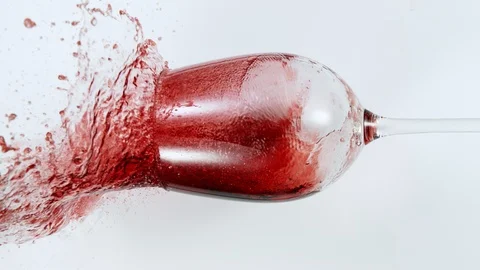 Super Slow Motion Top Shot of Falling Glass with Red Wine on White Cloth at Stock Footage 125477968