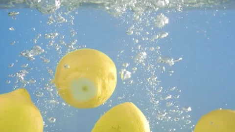 Super slow motion video of lemon falling into water with a splash. Blue 스톡 동영상 274814085