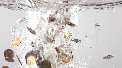 Super slow motion video of multiple coins sinking in water. Crisis concept 库存影片 60423847