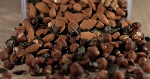 Super slow motion, Vivid Image Of Nuts Splashing Onto Textured Background Stock Footage 330110982