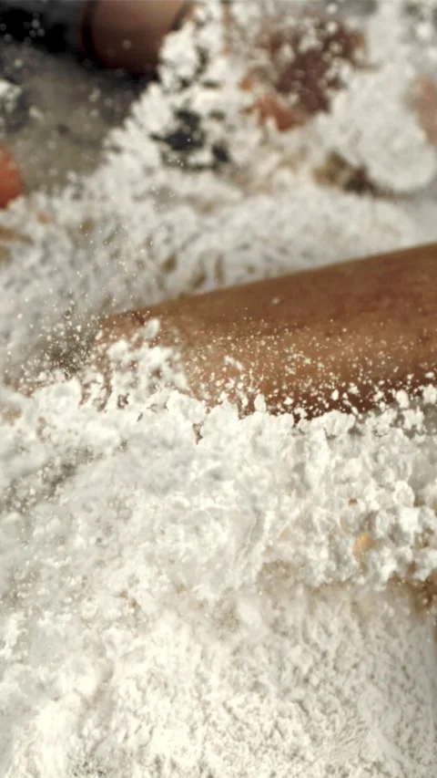 Super slow motion wooden rolling pin falls in a pile of flour on the table Stock Footage 335283269